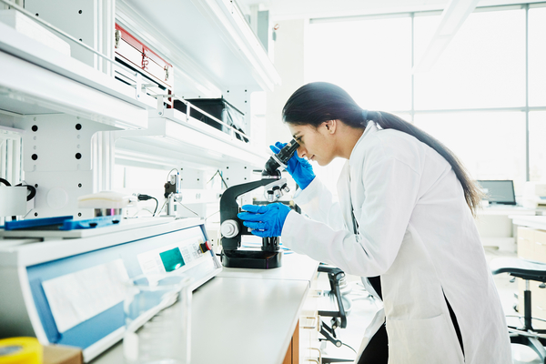 Female scientist using microscope while working in laboratory